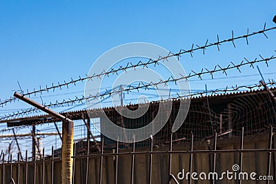 Steel barbed wire on the fence in the prison. Close-up Stock Photo