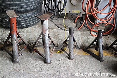 4 steel bars for supporting wheels, car lift, concept, repair parts in garage. Stock Photo