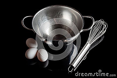 Steel bowl whisker eggs high angle with reflection on black Stock Photo