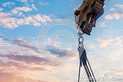 Steel chain attached to the excavator arm. Lifting gear against blue sky with space for text as an abstract industrial Stock Photo