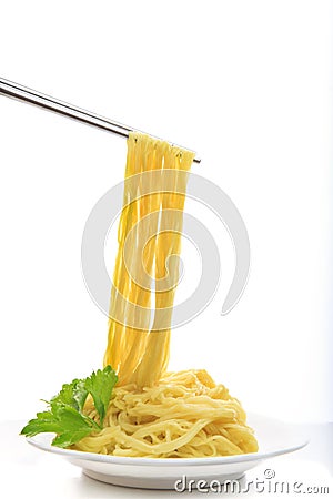 Steel chopstick holding chinese yellow eggs noodle on white disk Stock Photo