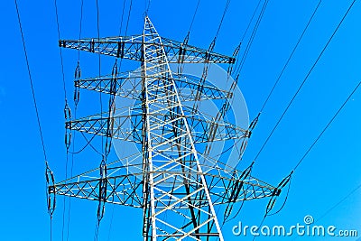 Steel electricity pylon under bright blue sky Stock Photo