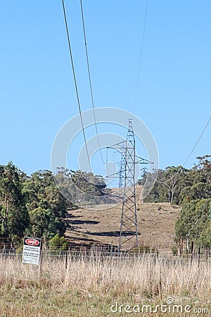 Steel electricity tower with low hanging wires and danger sign Stock Photo