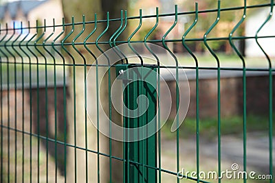 Steel grating fence made with wire on garden background. Sectional fencing installation. Stock Photo