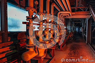 Steel industrial pipeline with valves and manometers in corridor of abandoned factory Stock Photo