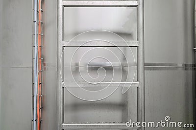 Steel ladder at the metal tank. Vertical Staircase Stock Photo