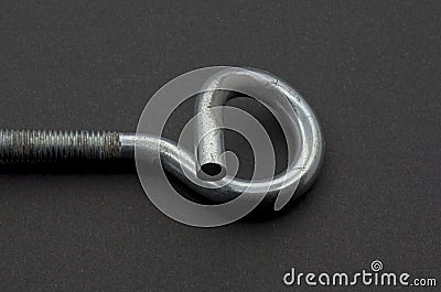 Steel pigtail screw hook on black background. Stock Photo