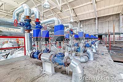 Steel pipelines and valves on factory producing blocks Stock Photo