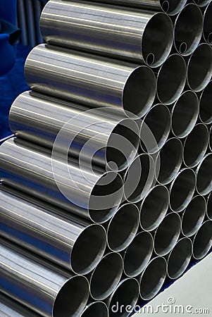 Steel pipes against industrial blurred background, close-up Stock Photo
