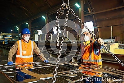 Steel Plant Workers Using Lifting Beam Stock Photo