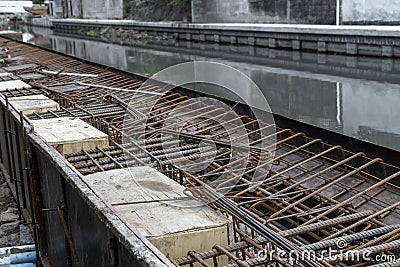 Steel reinforcing tie wire work at construction site of embankment for canal path and protecting riverbank collapse structures. Stock Photo