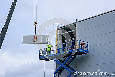 Sandwich panels wall mounting using crane and scissor lift Stock Photo