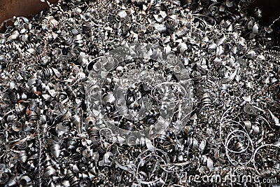 Steel scrap materials recycling. Aluminum chip waste after machining metal parts on a cnc lathe. Closeup twisted spiral steel Stock Photo