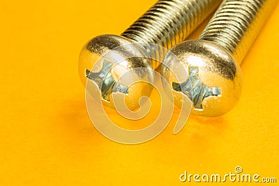 Steel screw on a yellow background Stock Photo