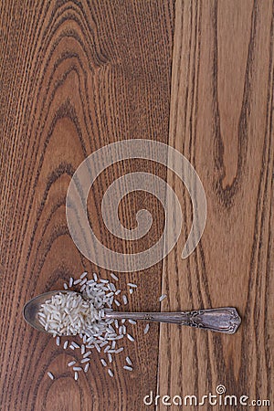 Steel teaspoon with dry uncooked white rice. Stock Photo