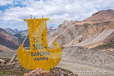 Stella on the road to Kumtor gold mine with inscription Barskoon mountain pass Stock Photo