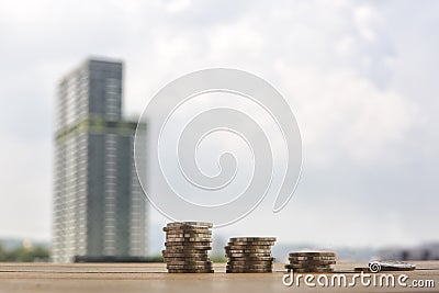 Step of coins stacks, gold coins on blurred building background Stock Photo
