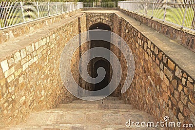 Step going down towards old well which is used for storage of water Stock Photo