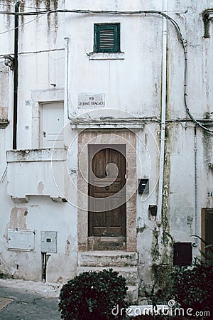 Step into History with Ostuni's White Building Stunning Wooden Door with Antique Charm Stock Photo