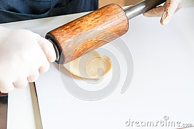 Step by step, baker prepares bread. baker slaps on dough. making bread, hand with rolling pin and flour Stock Photo