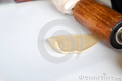 Step by step, baker prepares bread. baker slaps on dough. making bread, hand with rolling pin and flour Stock Photo