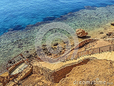 Stepped descent into the rock to the coral reef in the Red Sea Stock Photo
