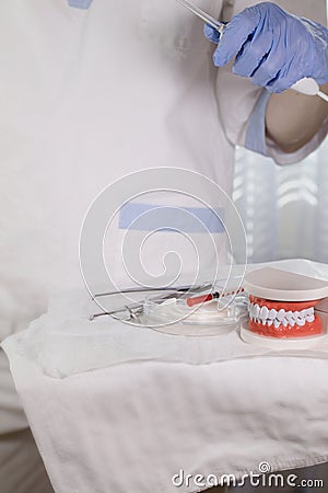 Sterile cotton napkins, human jaw model and stomatological tools on a table. Closeup Stock Photo