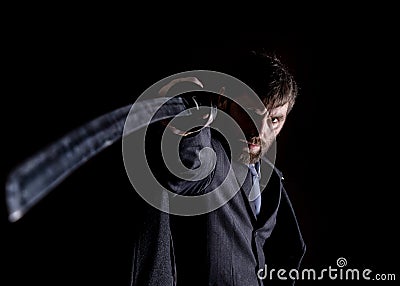 Stern angry businessman in a wool coat with sword in dark background Stock Photo