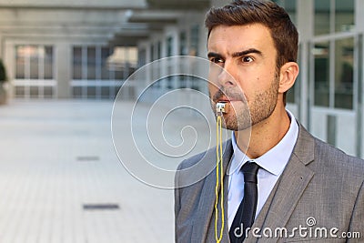 Stern man blowing the whistle in office space Stock Photo