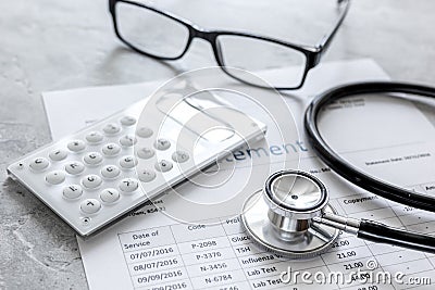 Stethoscope, billing statement for doctor`s work in medical center stone background Stock Photo