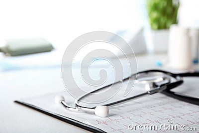 Stethoscope, cardiogram and forms on table, closeup Stock Photo