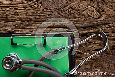 Stethoscope and clipboard on wood table top view . Medical background. Concept for diet, healthcare, nutrition or medical Stock Photo