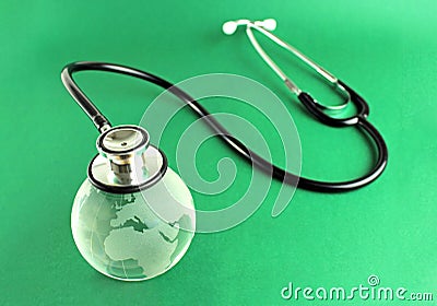 Stethoscope on a crystal globe, conceptual image - green background Stock Photo