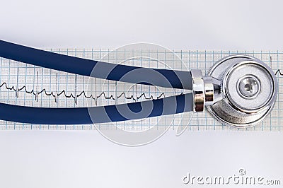 Stethoscope lying horizontally on tape electrocardiogram, airtubes covering recorded heartbeat rhythm with transition contour in h Stock Photo