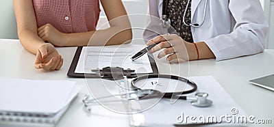 Stethoscope, medical prescription form are lying against the background of a doctor and patient discussing health exam Stock Photo