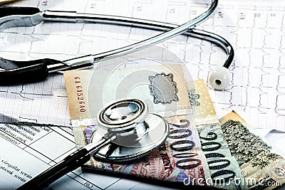 Stethoscope and money & x28; forint & x29; on electrocardiogram. Stock Photo