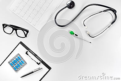 Stethoscope in the office of doctors.Top view of doctor`s desk table, blank paper on clipboard with pen. Copy space Stock Photo