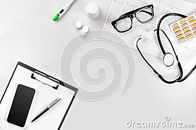 Stethoscope in the office of doctors.Top view of doctor`s desk table, blank paper on clipboard with pen. Copy space Stock Photo