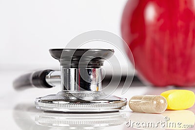 Stethoscope, pills and apple on white background Stock Photo