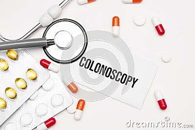 Stethoscope, pills and notebook with Colonoscopy word on medical desk Stock Photo