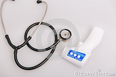 Stethoscope, pulse oximeter and thermometer gun on white background. Phonendoscope. Infrared isometric thermometer gun Stock Photo