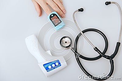 Stethoscope, pulse oximeter and thermometer gun on white background. Phonendoscope. Infrared isometric thermometer gun Stock Photo