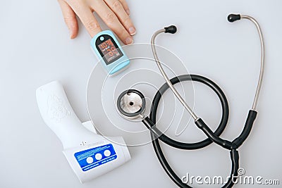 Stethoscope, pulse oximeter and thermometer gun on white background. Phonendoscope. Infrared isometric thermometer gun Stock Photo