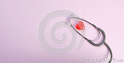 Close up Stethoscope and red heart on pale pink isolated background with copy space for text. Close up, top view. Medical equipme Stock Photo