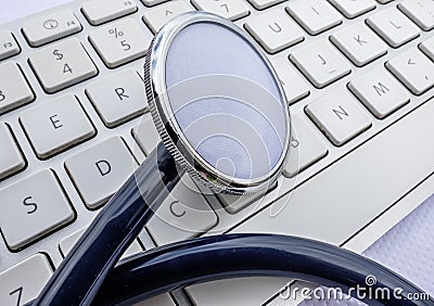 Doctor`s stethoscope seen on a computer keyboard. Stock Photo