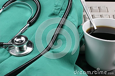 Stethoscope with smock, coffee & keyboard. Stock Photo