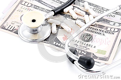 Stethoscope and some pills on dollars Stock Photo