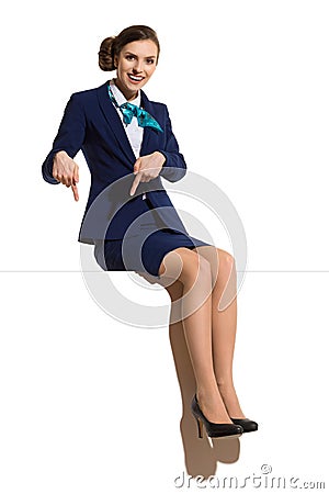 Stewardess Is Sitting On A Banner And Pointing Down Stock Photo