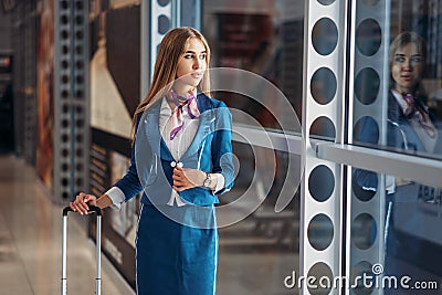 Stewardess with hand luggage and coffee in airport Stock Photo