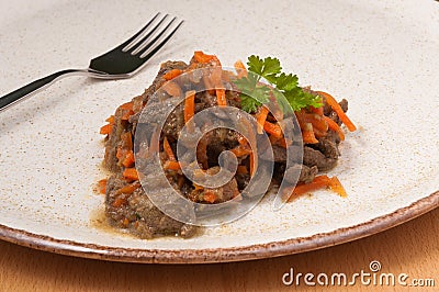 Stewed liver with carrots on a plate. close up Stock Photo